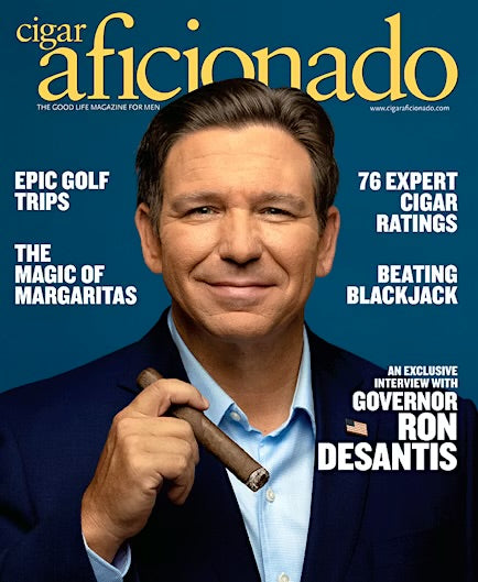 Cigar Aficionado cover featuring Florida Governor Ron Desantis holding a cigar with text about the magazine and its contents.