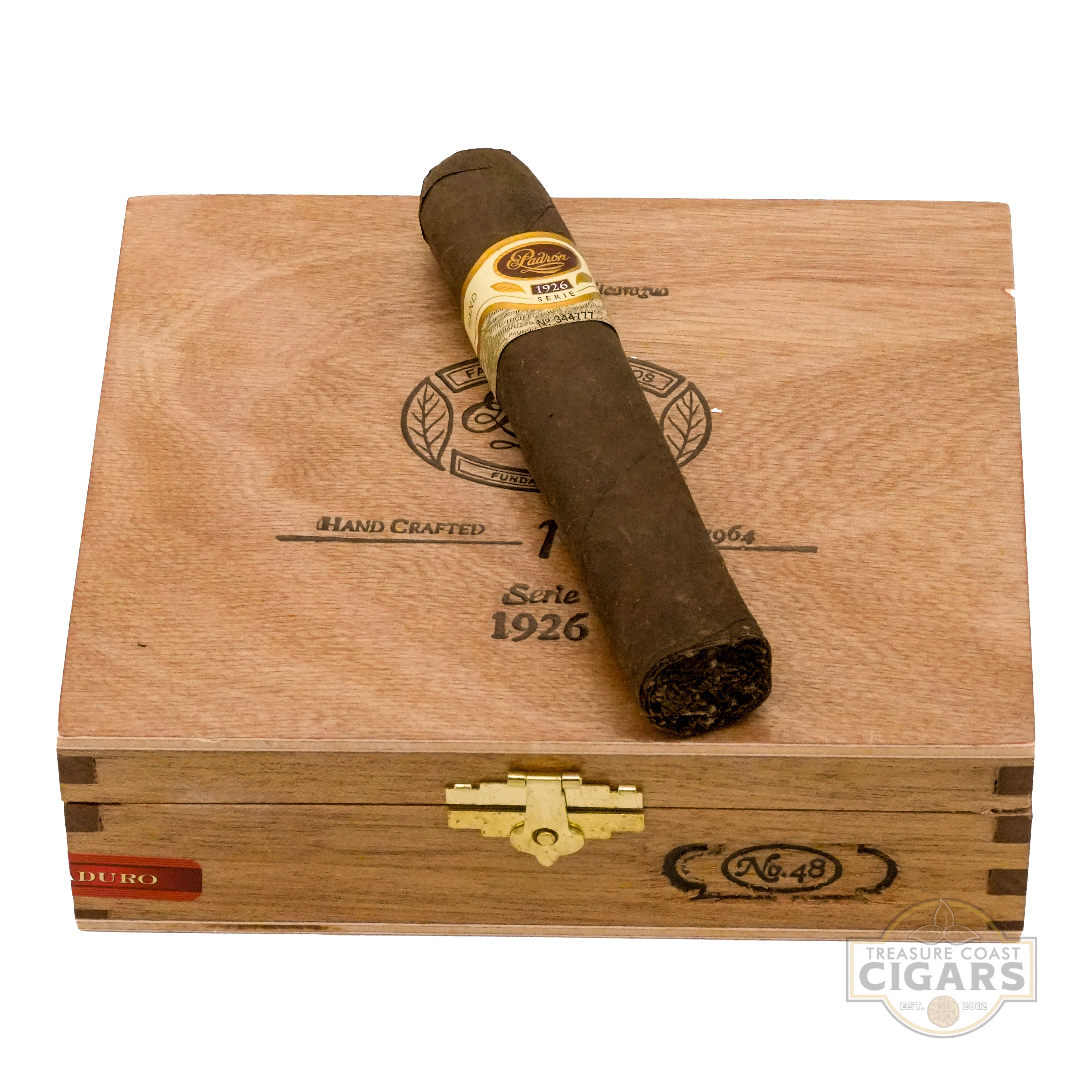 Cigar on top of a wooden cigar box with visible branding