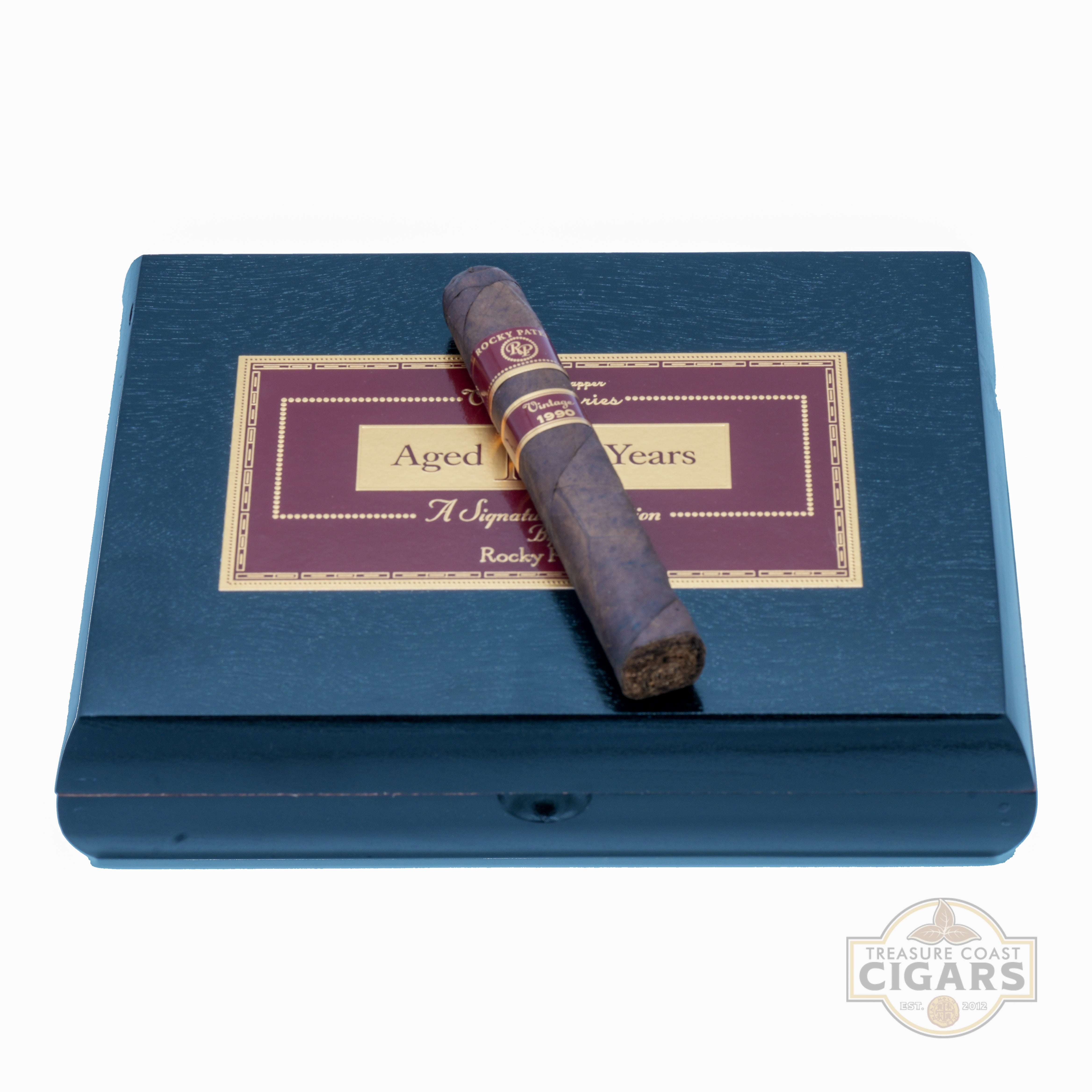 Cigar on a black box with a label indicating 'Aged' on a white background.