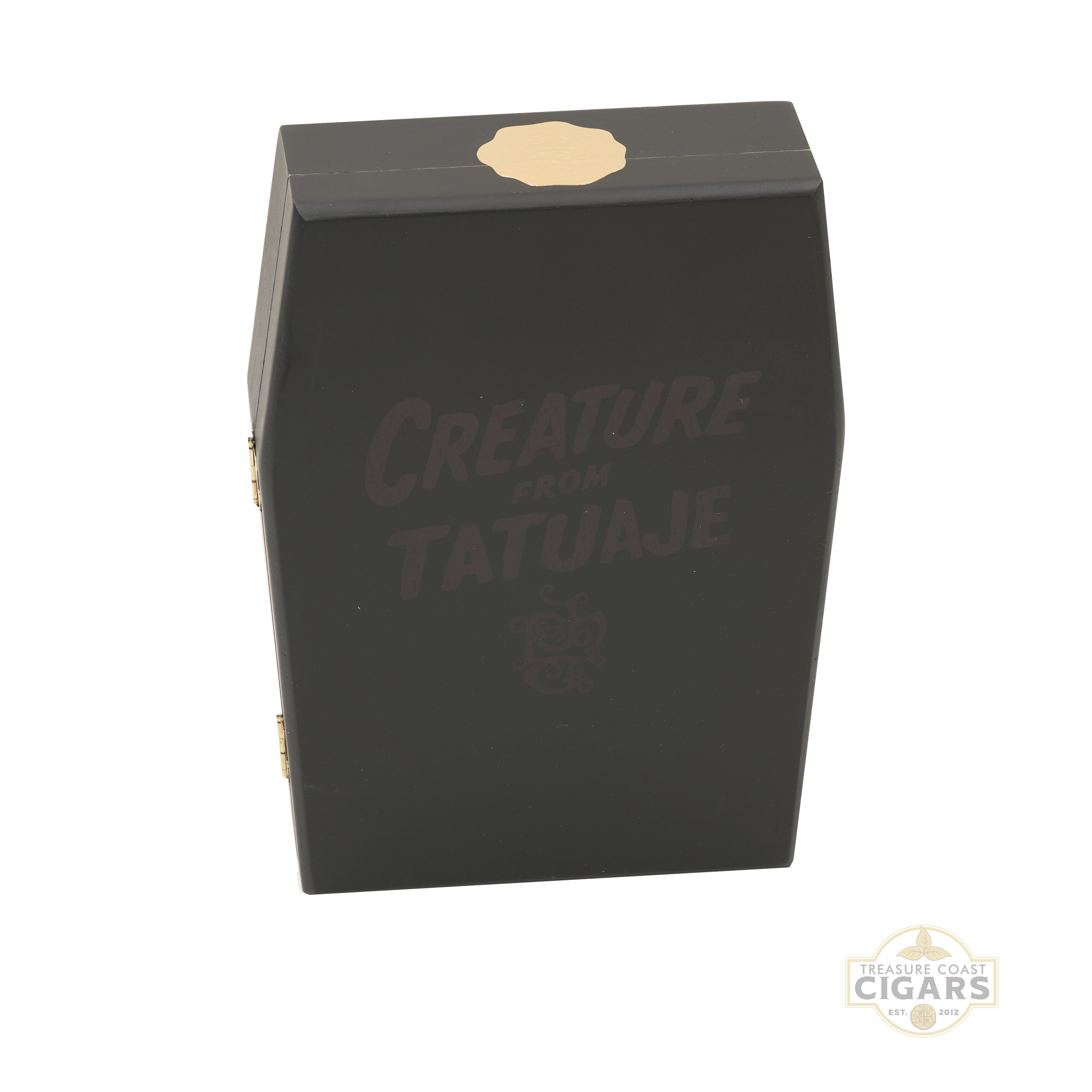 A black cigar box with the text 'CREATURE FROM TATUAJE' printed in dark gray on the front, featuring a gold seal on the top and gold side hinges, set against a plain white background.