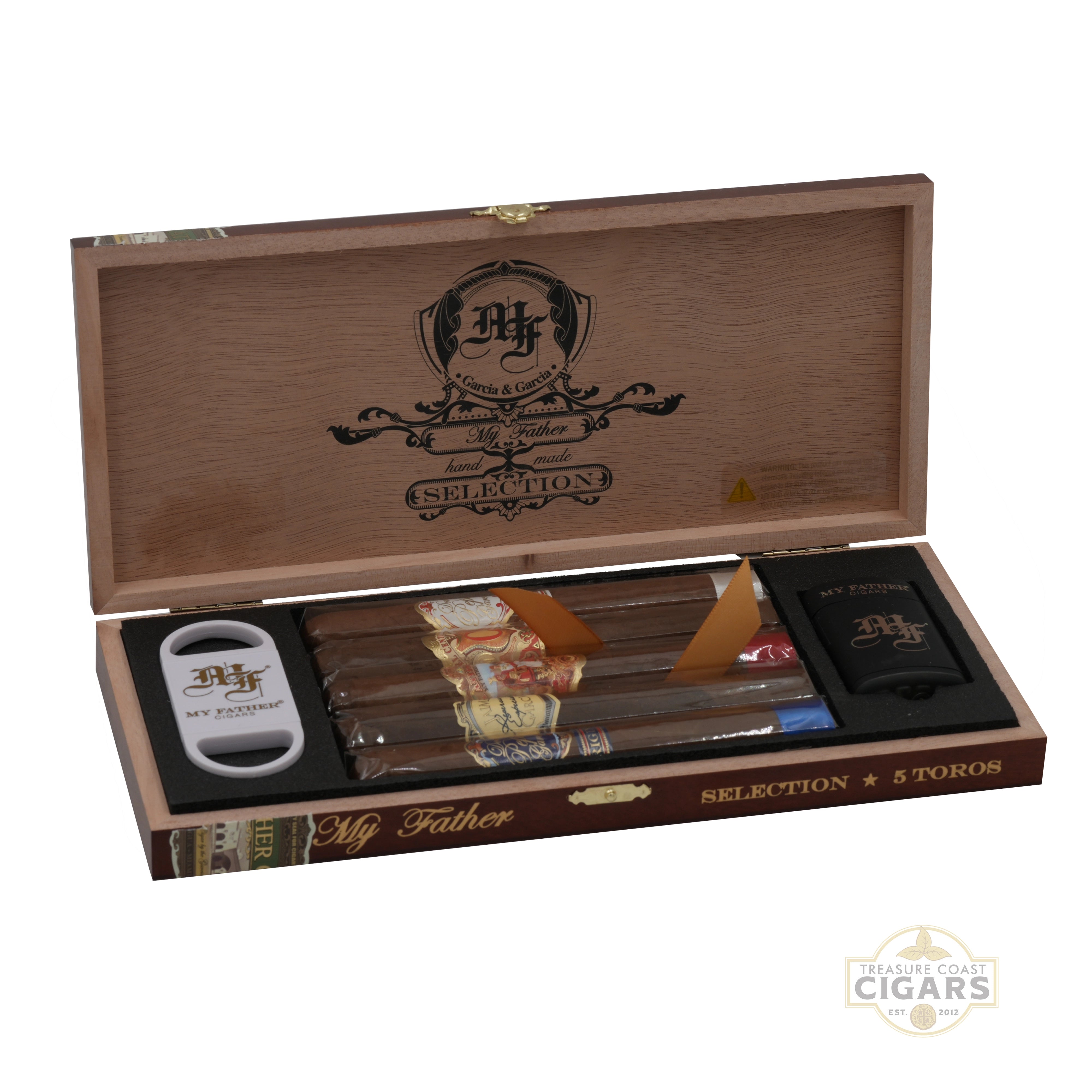 A wooden box containing an assortment of five My Father Cigars with cutter and lighter on a white background